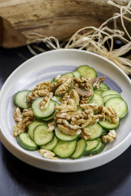 圆形瓷盘装的核桃仁青瓜片图片