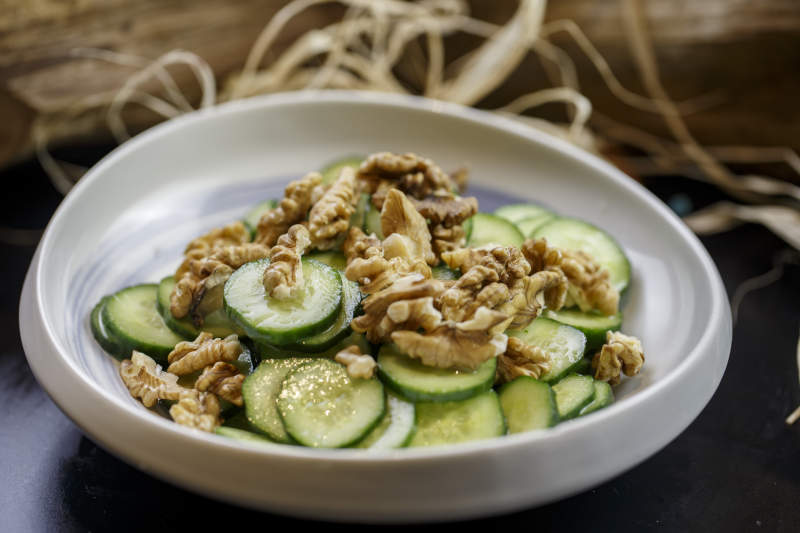 圆形瓷盘装的核桃仁青瓜片图片