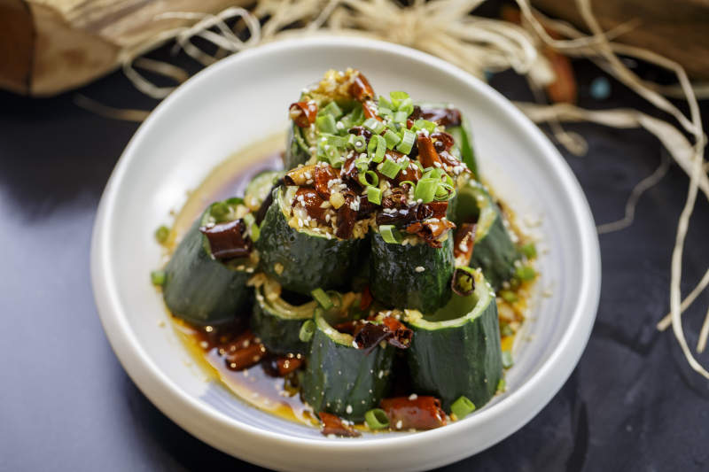 圆形白瓷盘装的风味青瓜段黄瓜图片