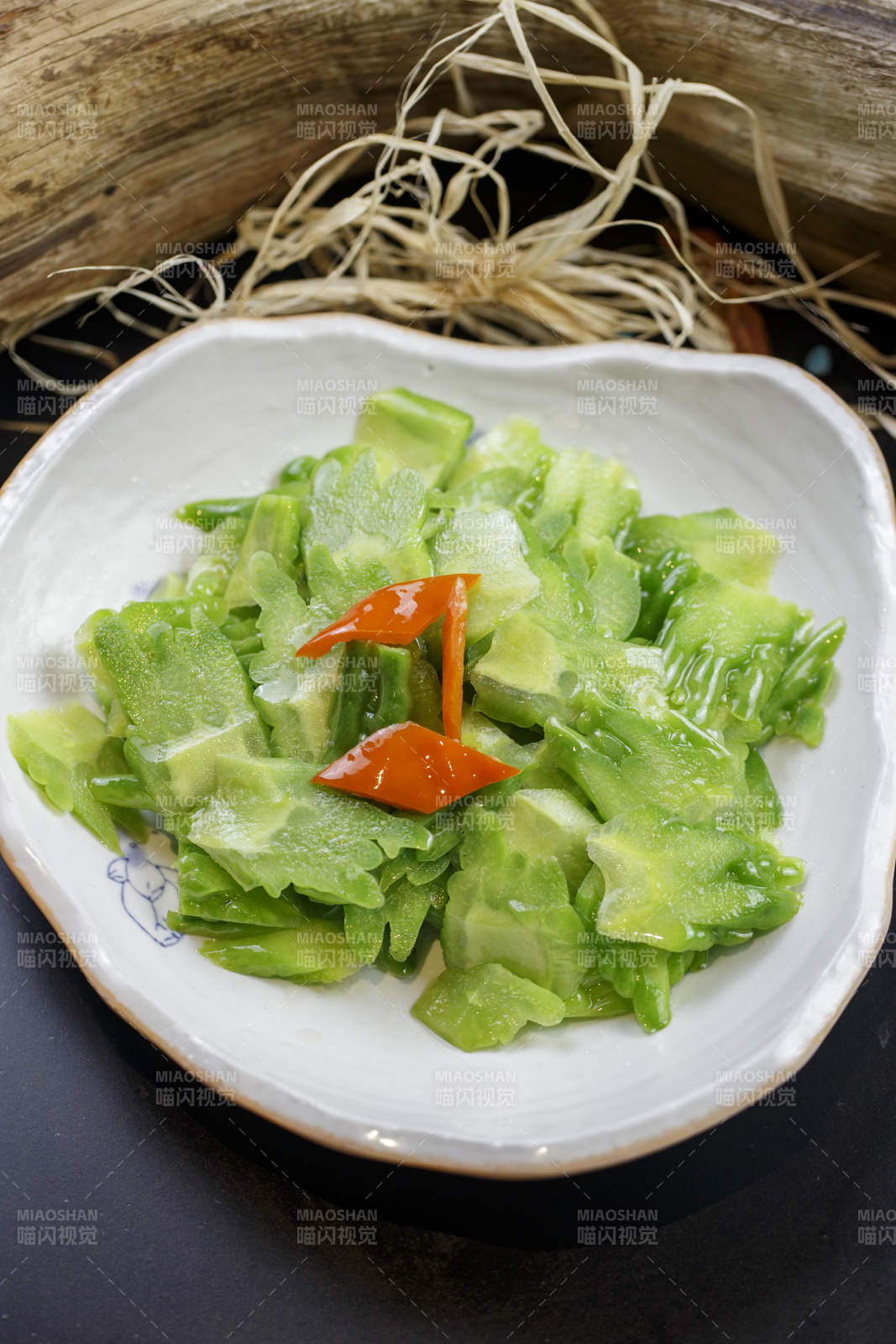 浪花边瓷盘装的炝炒苦瓜图片