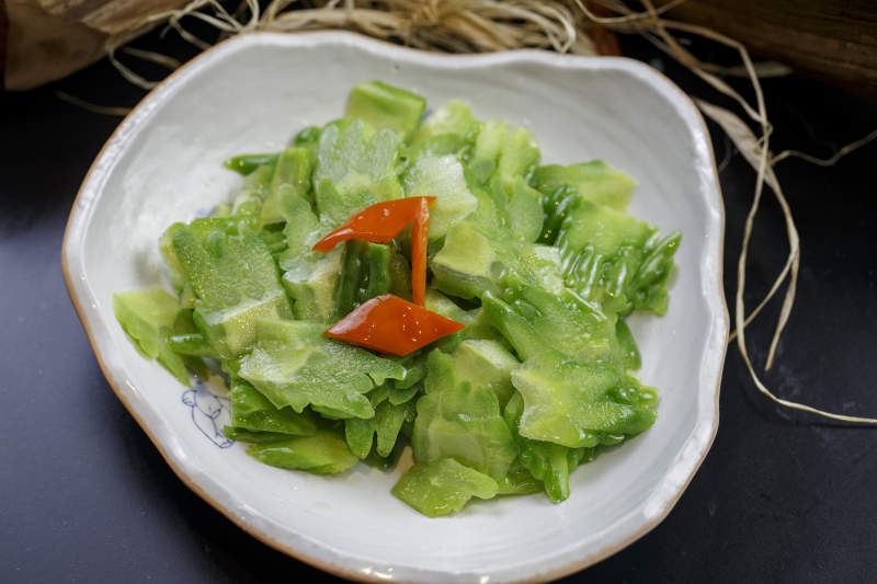 浪花边瓷盘装的炝炒苦瓜图片