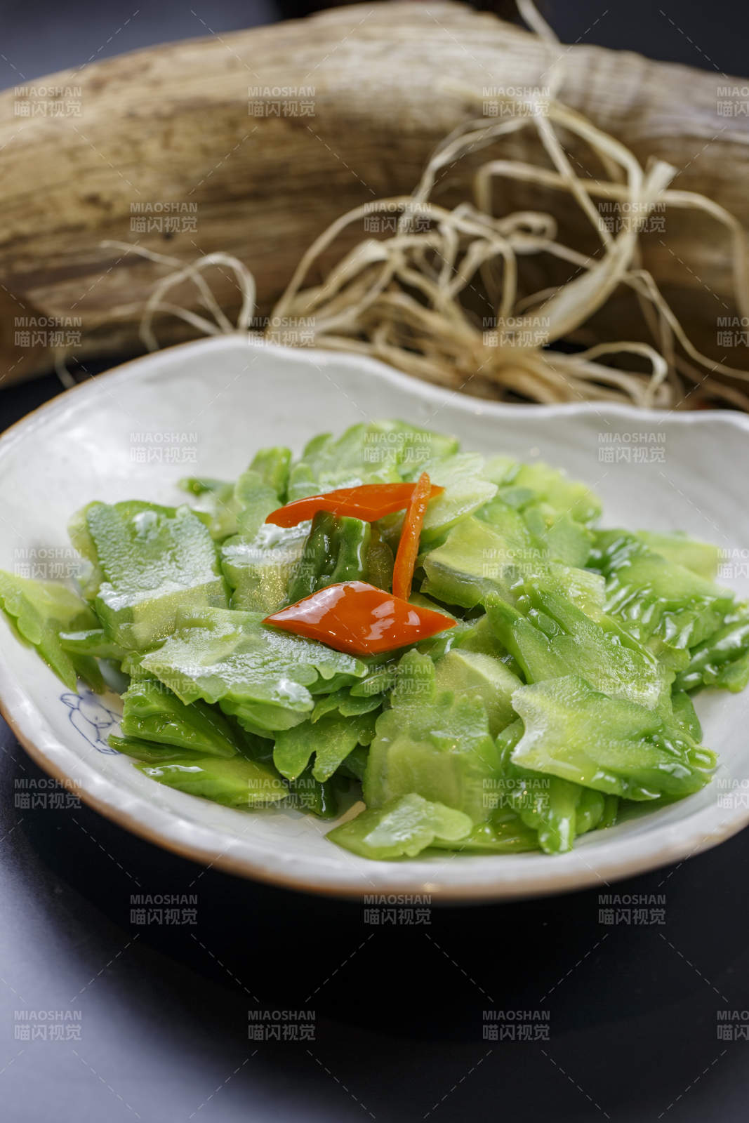 浪花边瓷盘装的炝炒苦瓜图片