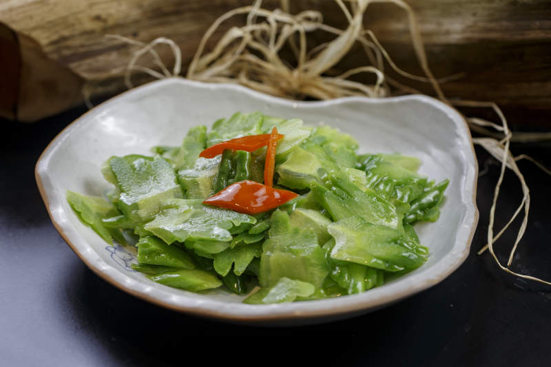 浪花边瓷盘装的炝炒苦瓜图片