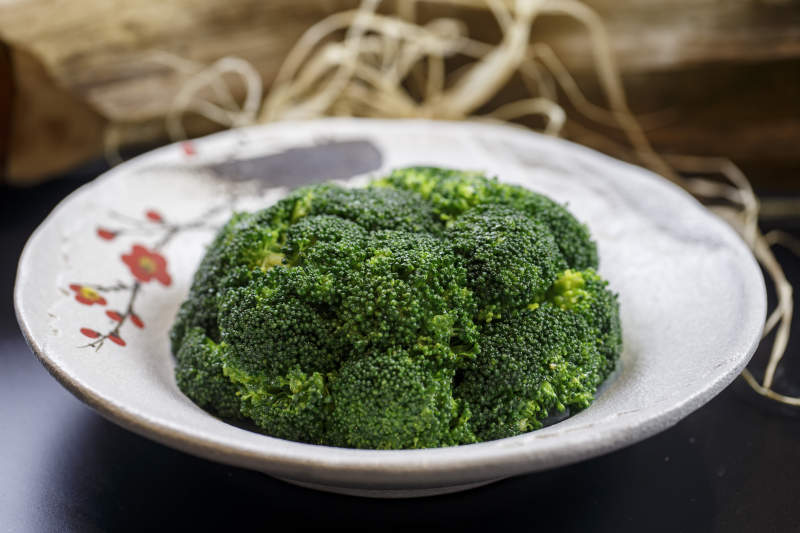 梅花图案瓷盘装的白灼西蓝花图片