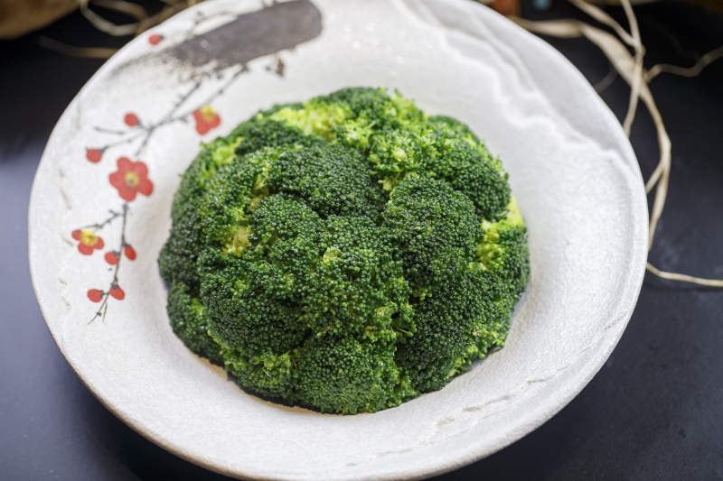 梅花图案瓷盘装的白灼西蓝花图片