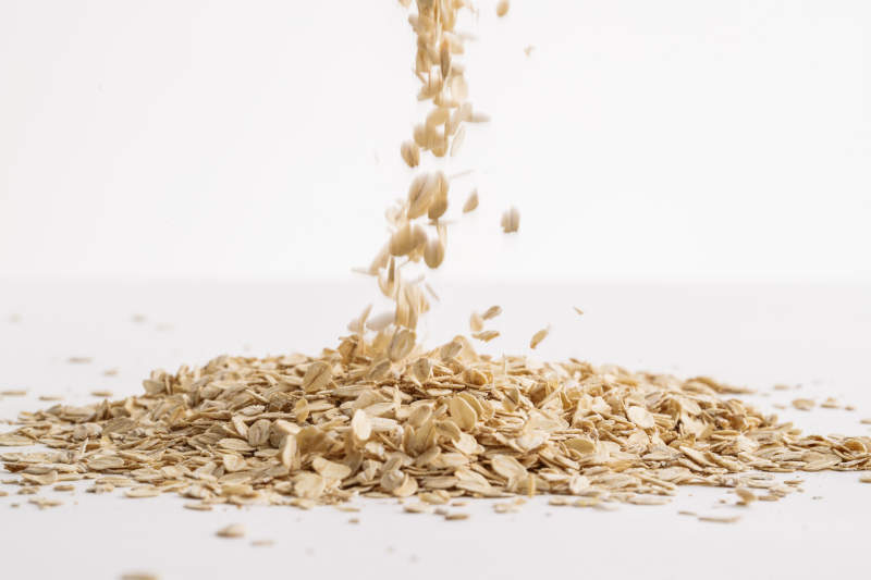 倾倒在白色背景上的健康食品燕麦片图片