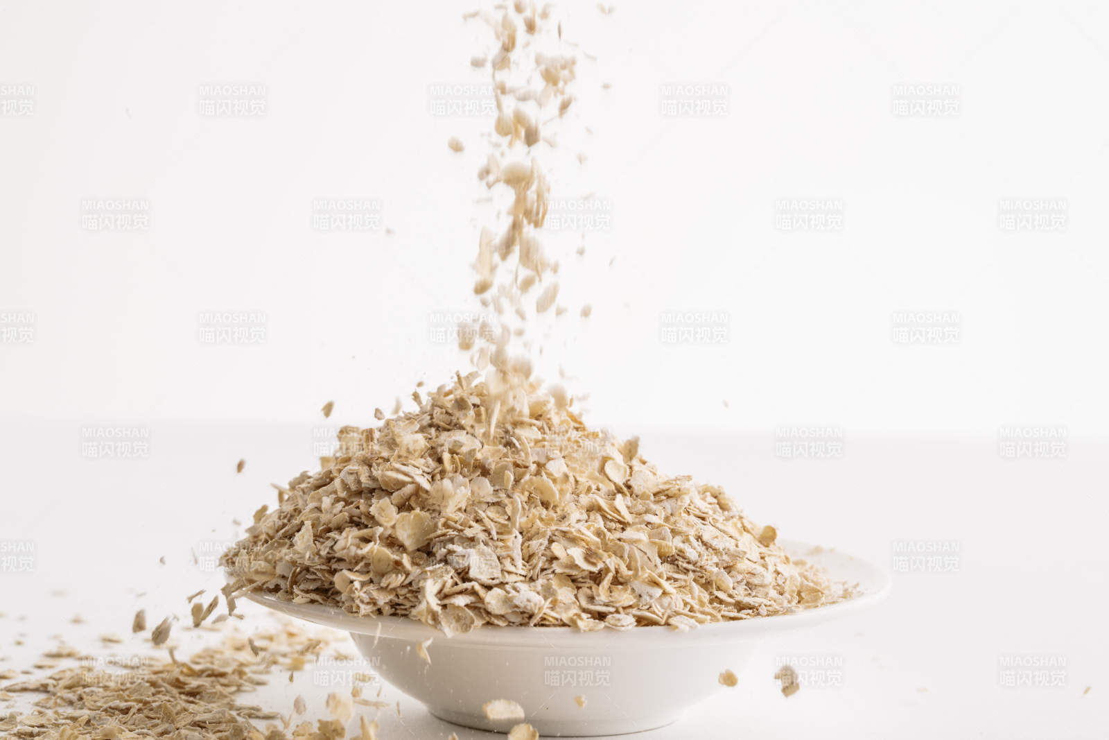 倾倒在白色背景上的健康食品燕麦片图片