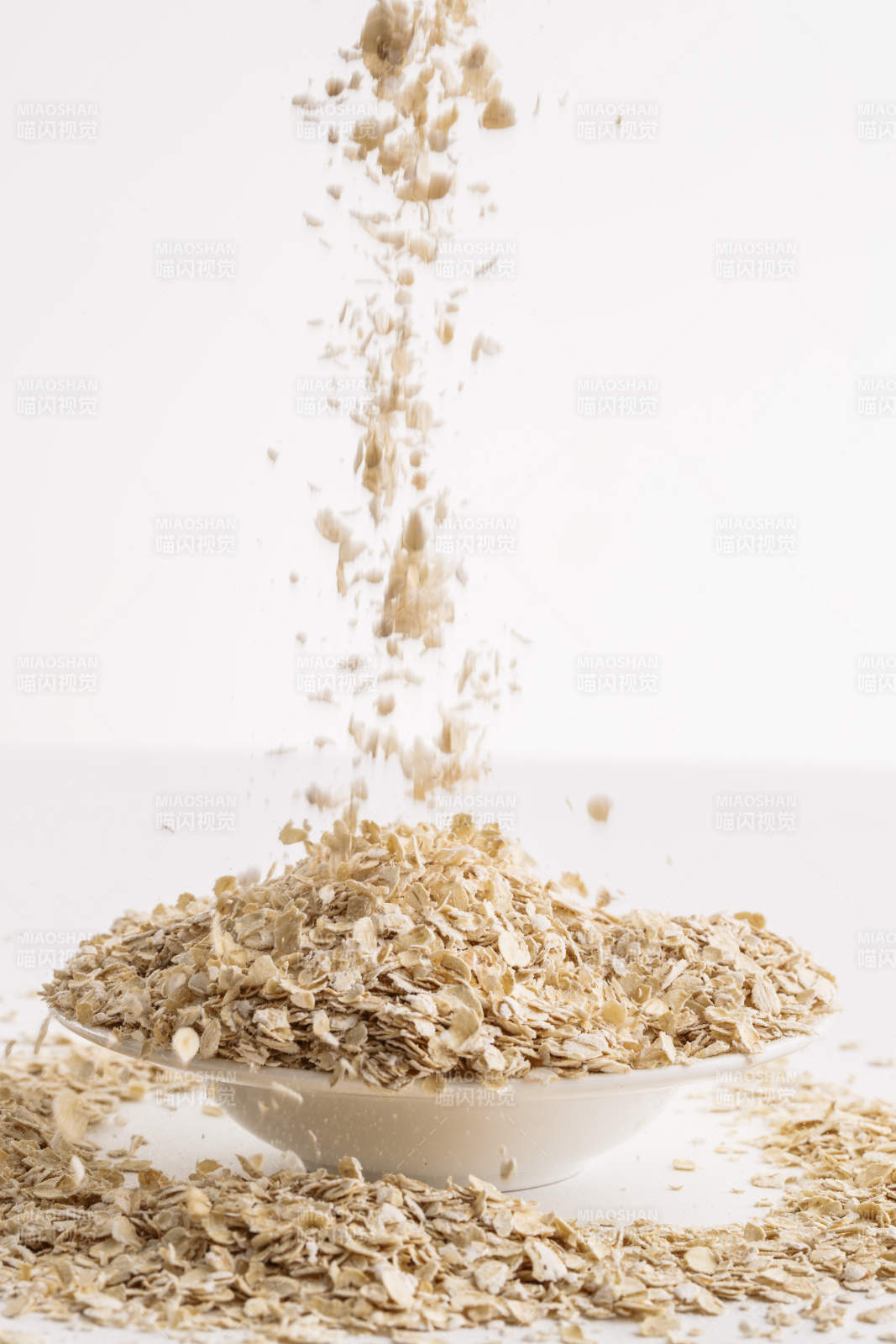 倾倒在白色背景上的健康食品燕麦片图片