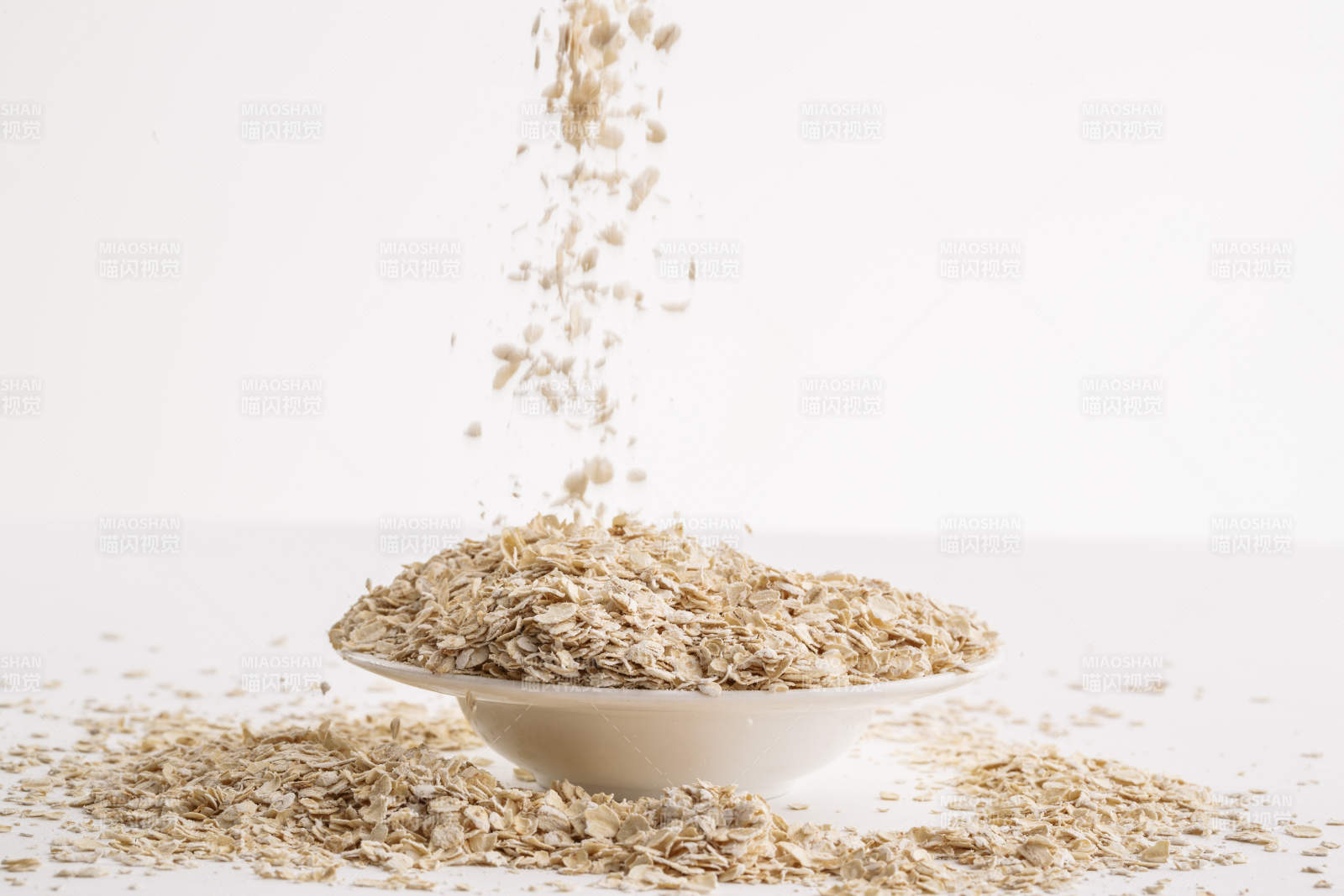 倾倒在白色背景上的健康食品燕麦片图片