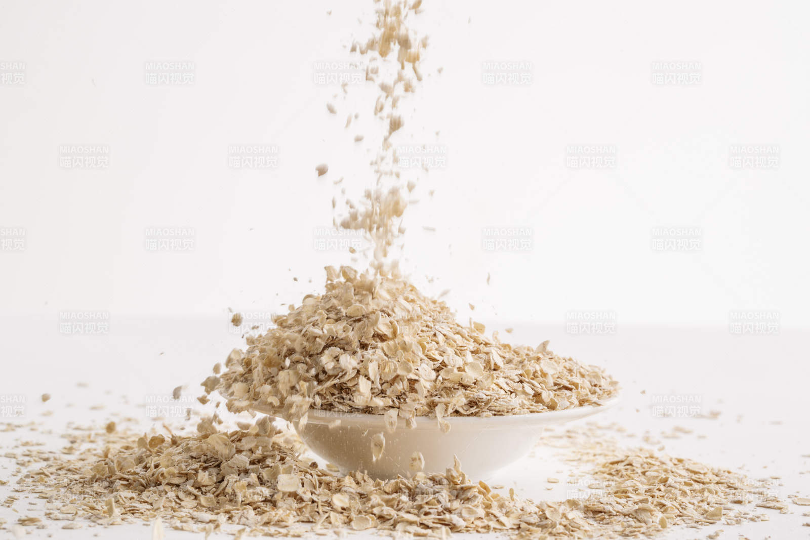 倾倒在白色背景上的健康食品燕麦片图片