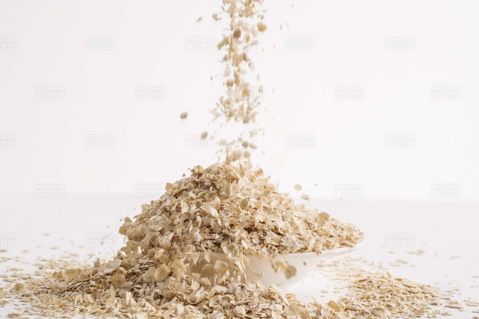 倾倒在白色背景上的健康食品燕麦片图片