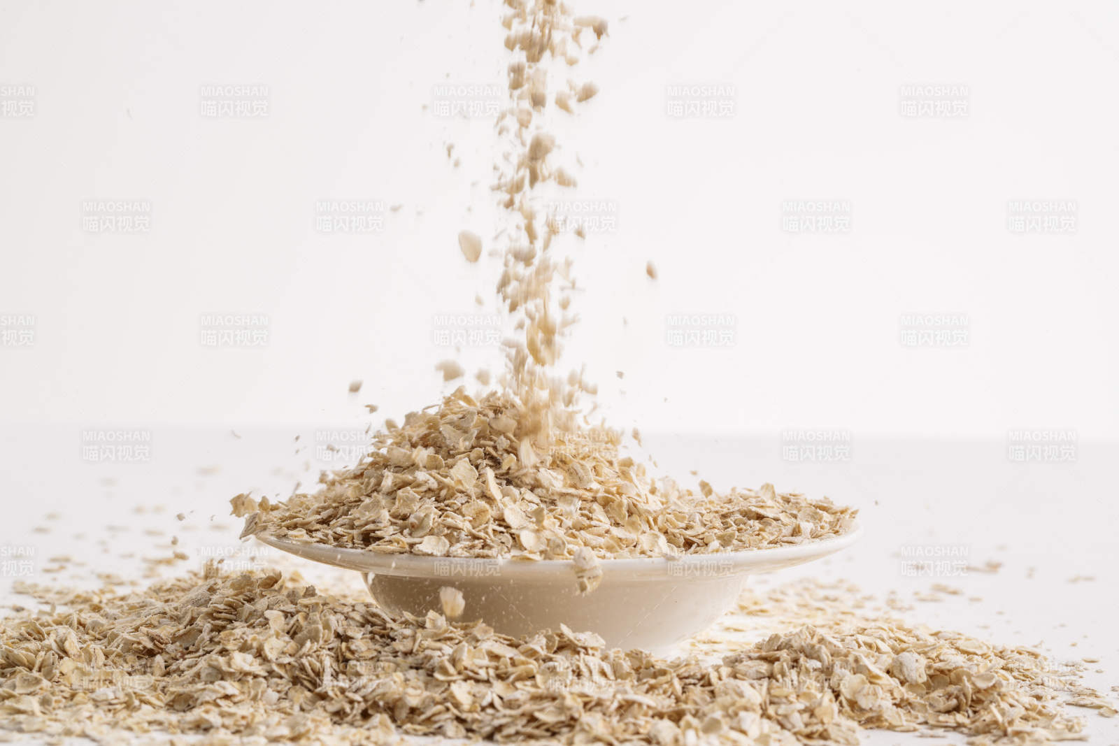 倾倒在白色背景上的健康食品燕麦片图片