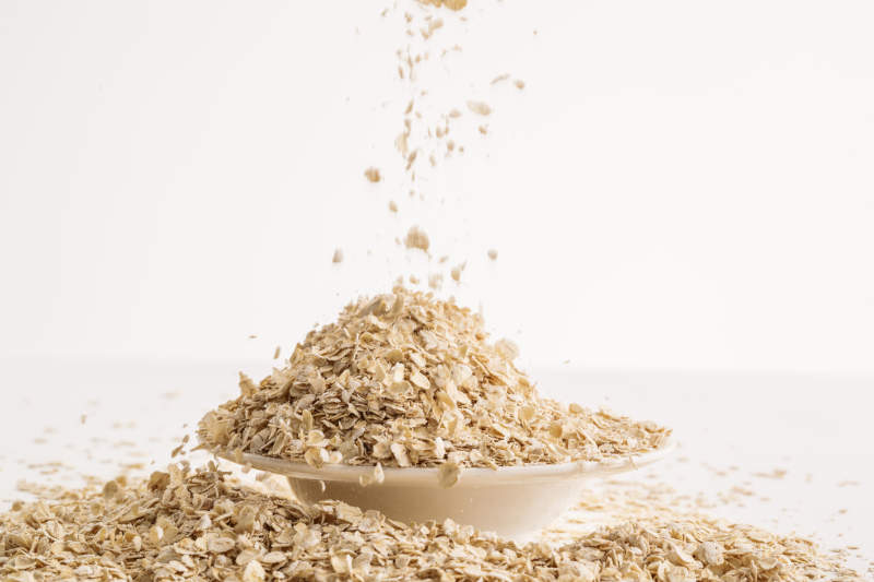 倾倒在白色背景上的健康食品燕麦片图片