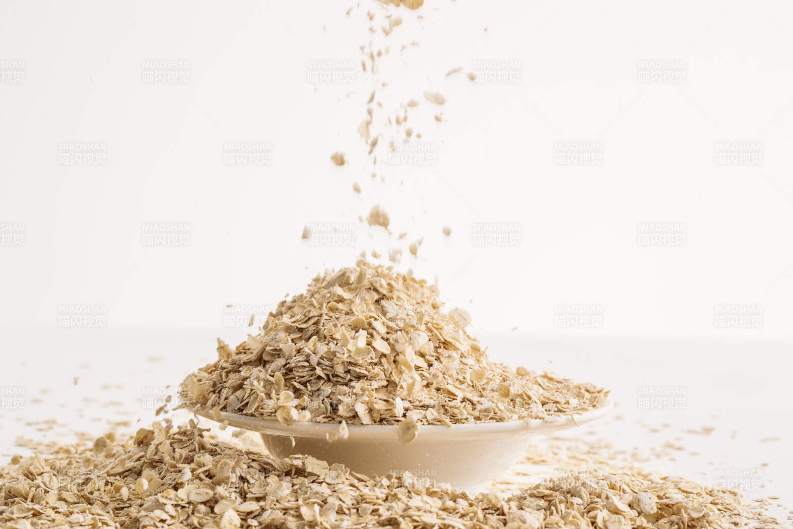 倾倒在白色背景上的健康食品燕麦片图片