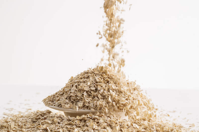 倾倒在白色背景上的健康食品燕麦片图片