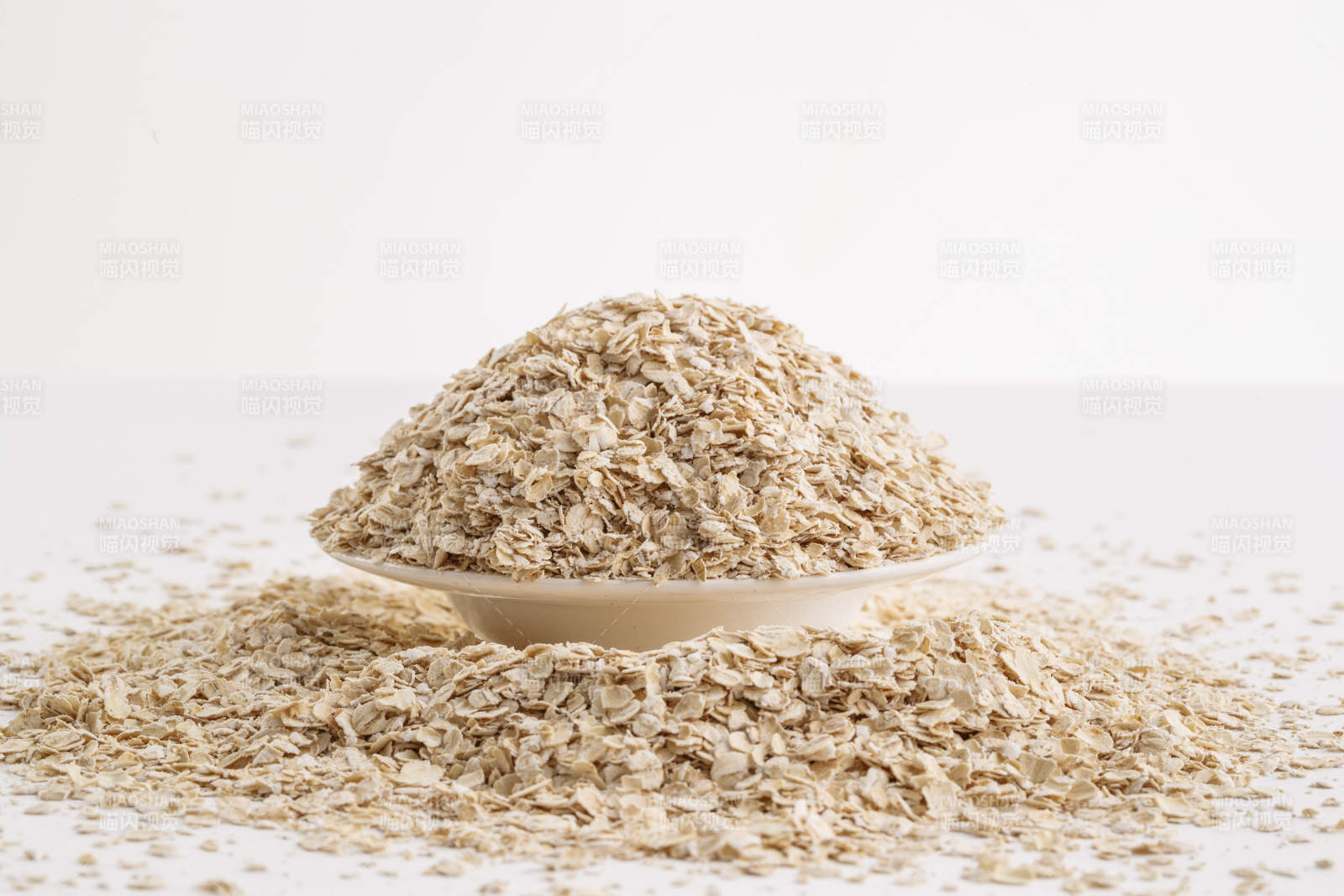 倾倒在白色背景上的健康食品燕麦片图片