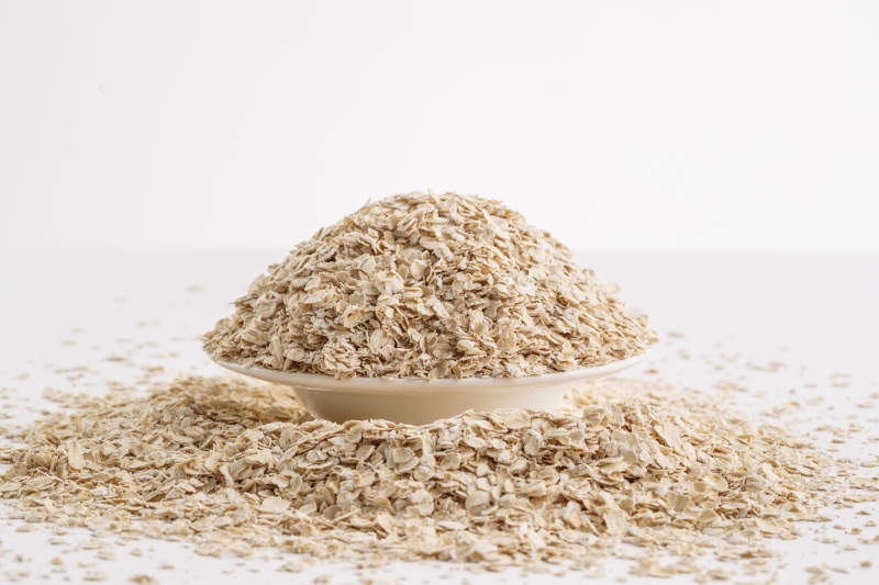 倾倒在白色背景上的健康食品燕麦片图片