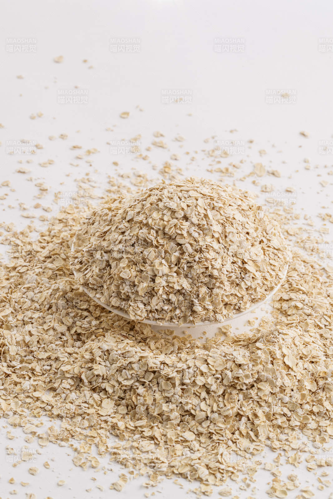 倾倒在白色背景上的健康食品燕麦片图片