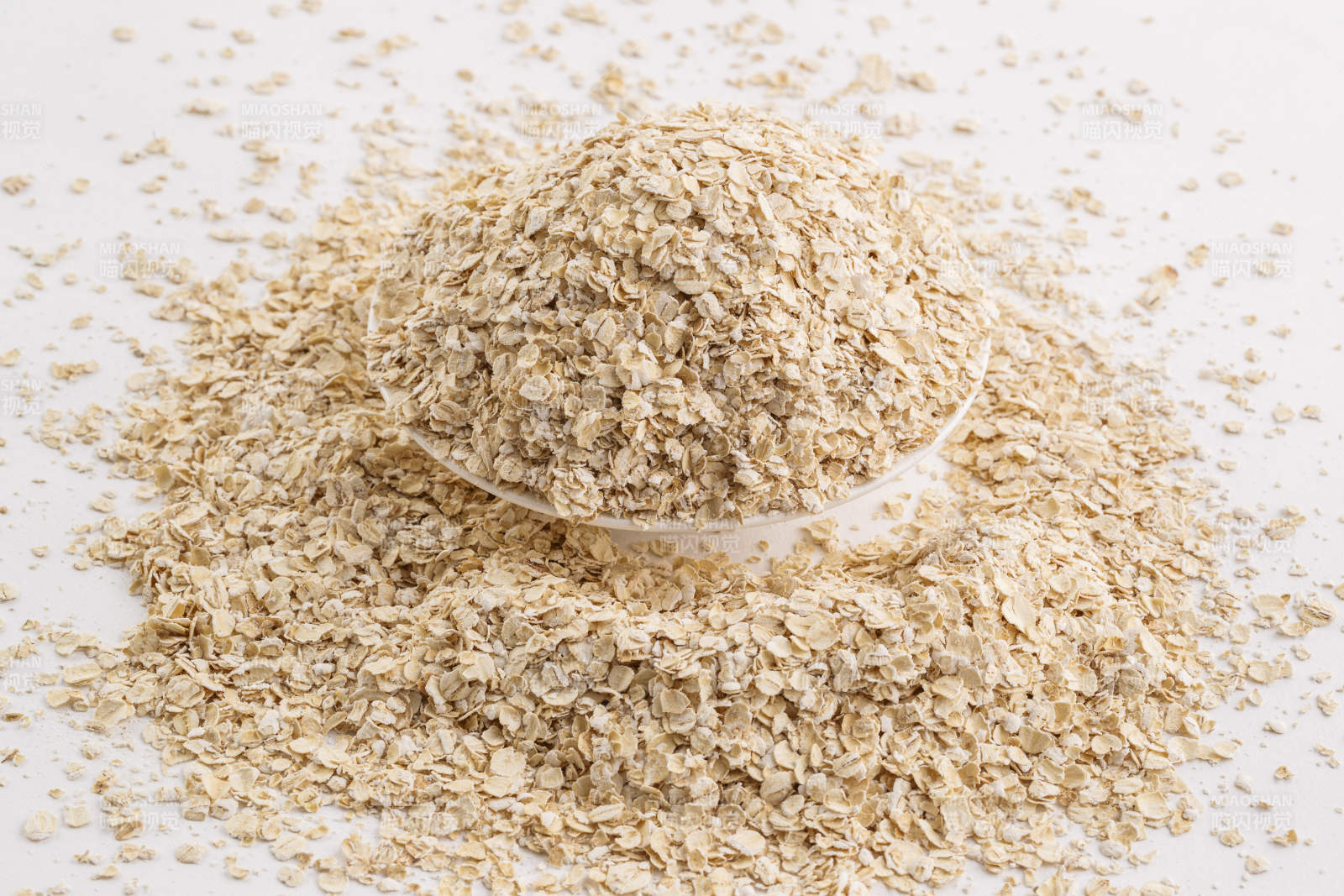 倾倒在白色背景上的健康食品燕麦片图片