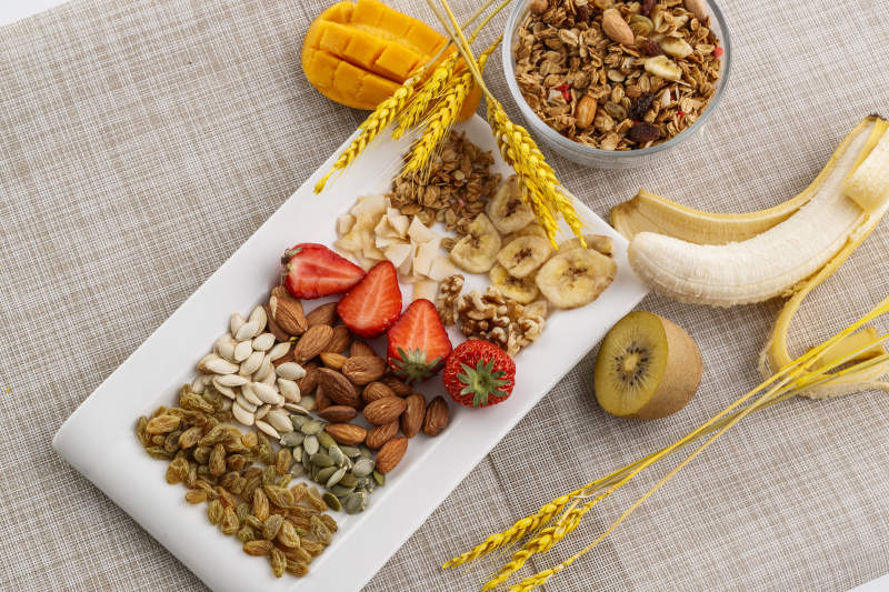 自制的水果坚果混合燕麦铺洒摆放在桌子上图片