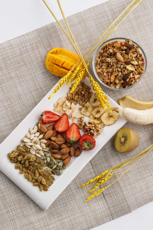自制的水果坚果混合燕麦铺洒摆放在桌子上图片