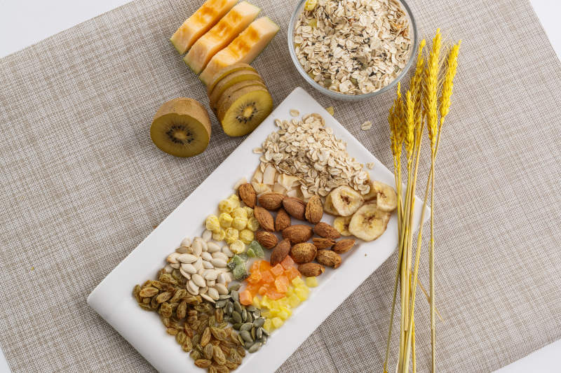 自制的水果坚果混合燕麦铺洒摆放在桌子上图片