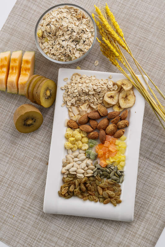 自制的水果坚果混合燕麦铺洒摆放在桌子上图片