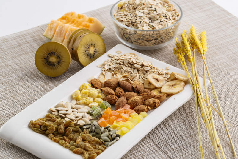 自制的水果坚果混合燕麦铺洒摆放在桌子上图片