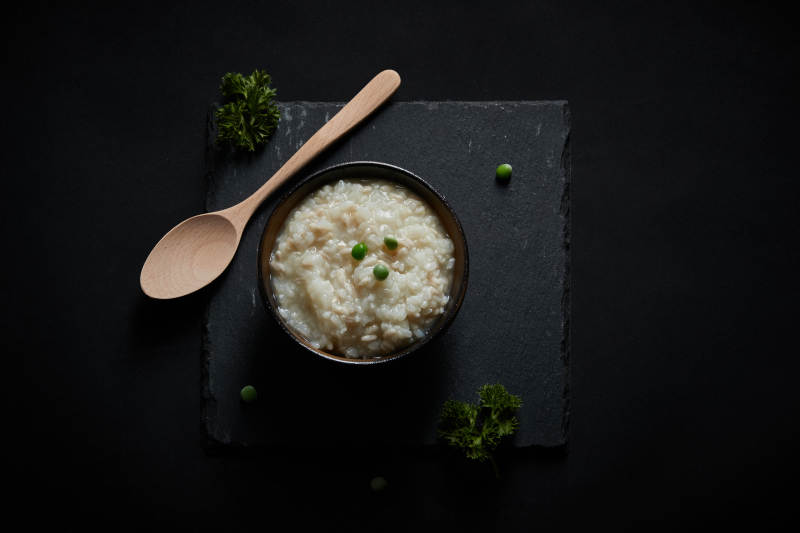 黑色青石板上摆放的燕麦米及蒸燕麦米饭图片