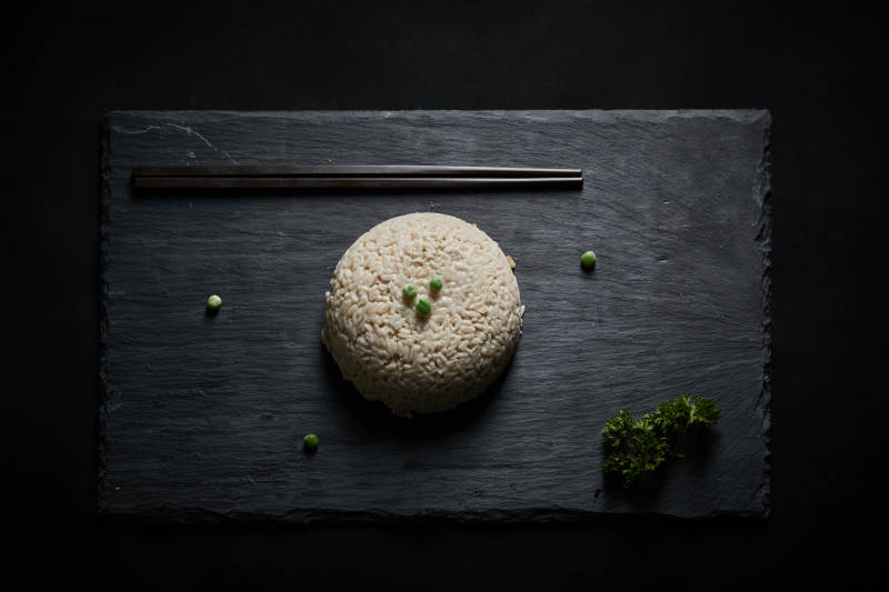 黑色青石板上摆放的燕麦米及蒸燕麦米饭图片