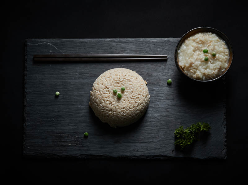 黑色青石板上摆放的燕麦米及蒸燕麦米饭图片