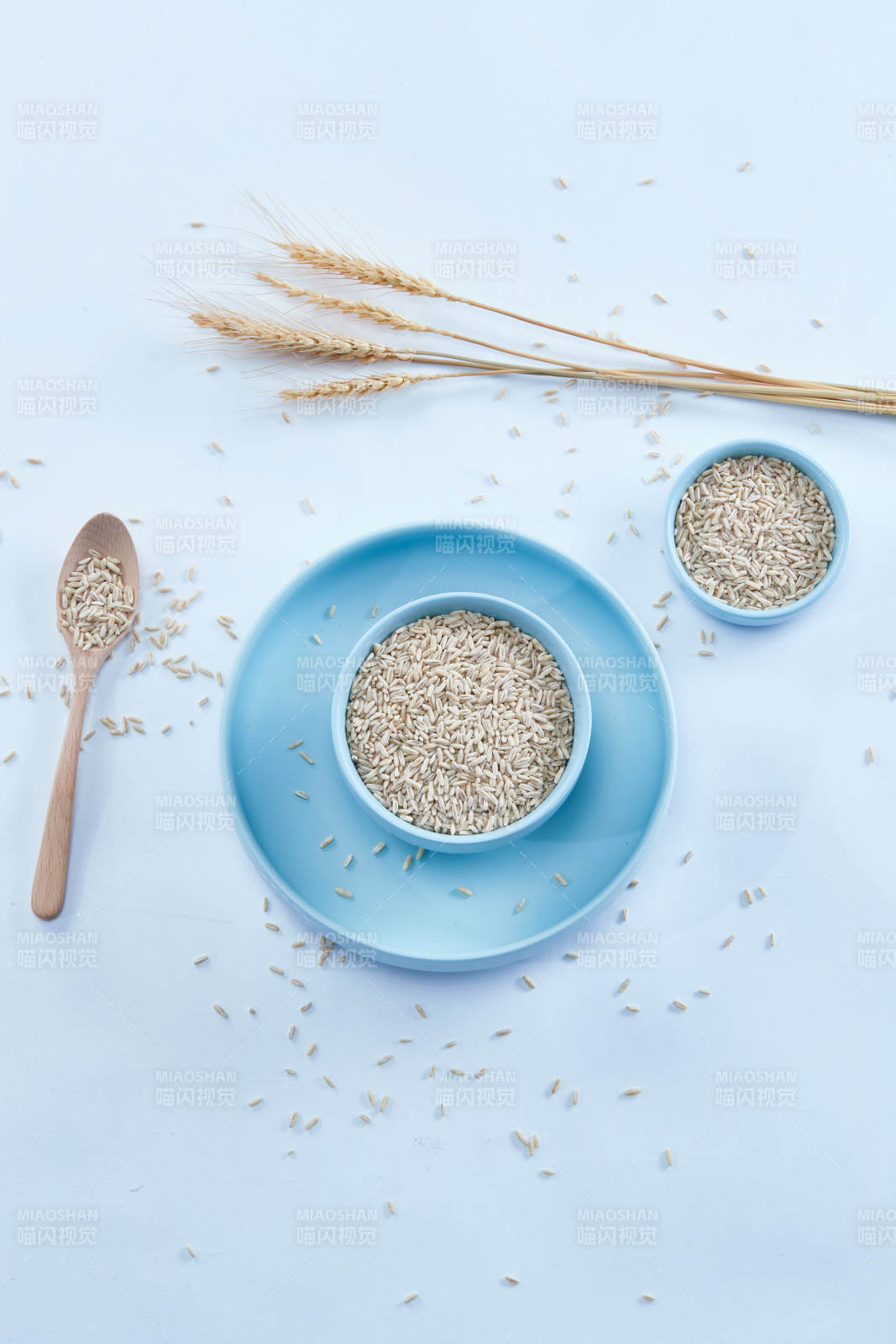 白色纸背景上的青釉瓷餐具及木质餐具装的燕麦米图片