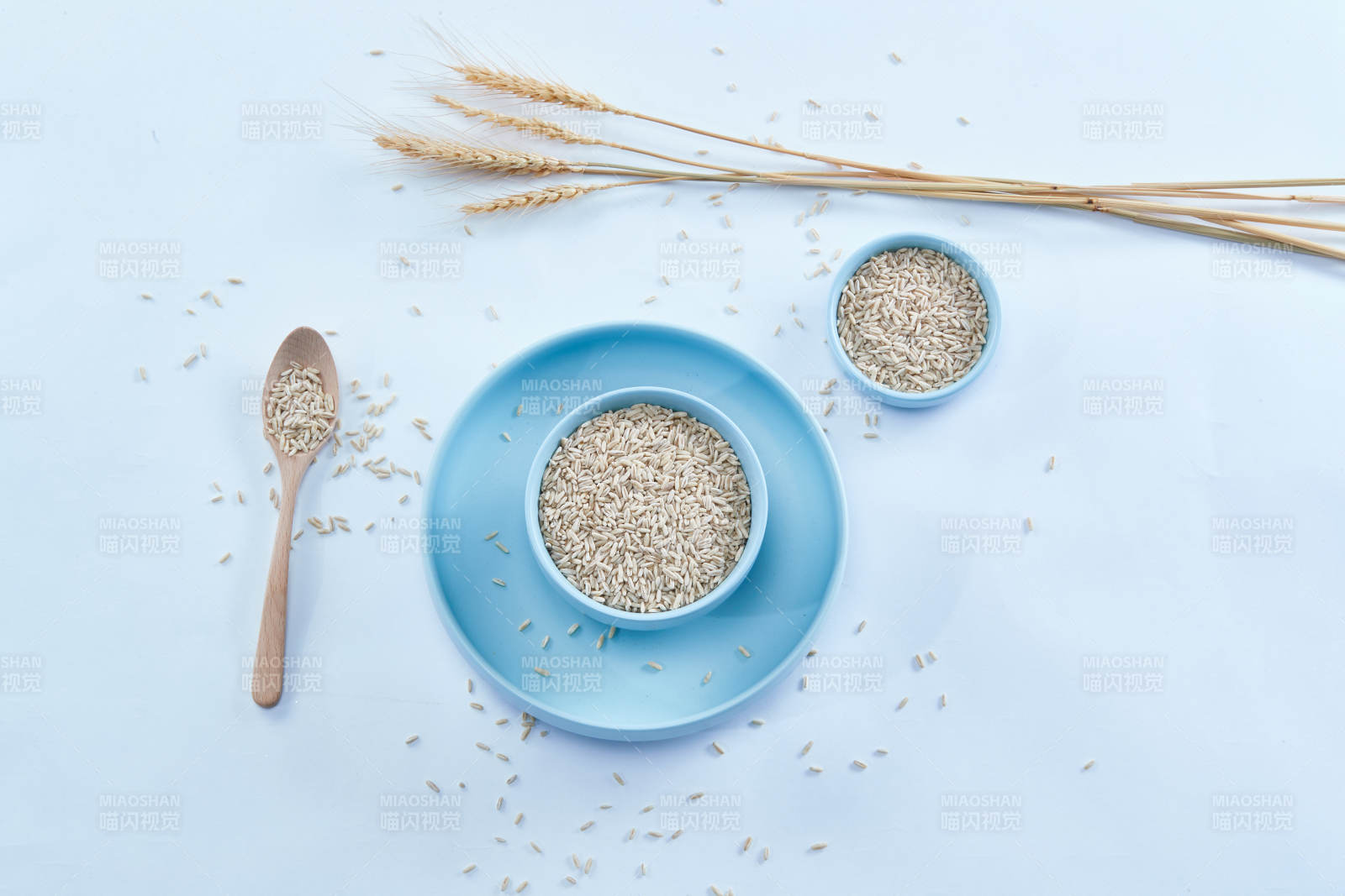 白色纸背景上的青釉瓷餐具及木质餐具装的燕麦米图片