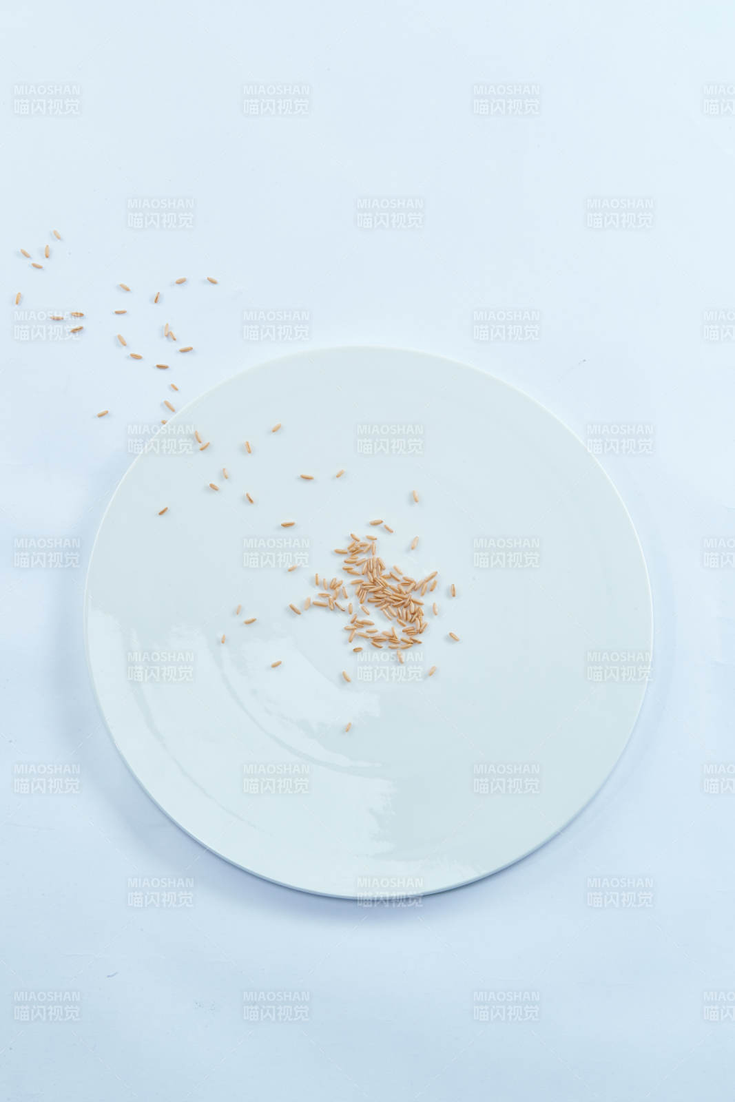 白色纸背景上的青釉瓷餐具及木质餐具装的燕麦米图片