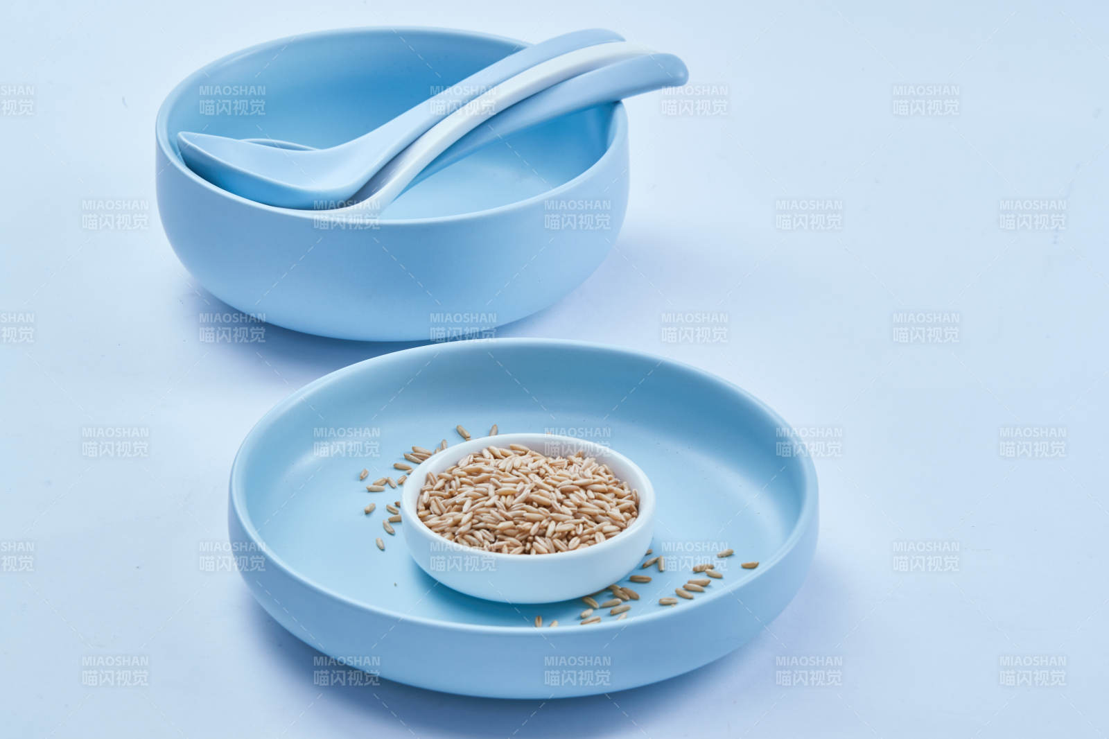 白色纸背景上的青釉瓷餐具及木质餐具装的燕麦米图片