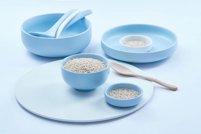 白色纸背景上的青釉瓷餐具及木质餐具装的燕麦米图片