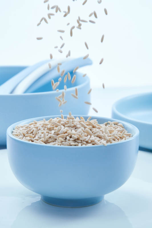 白色纸背景上的青釉瓷餐具及木质餐具装的燕麦米图片