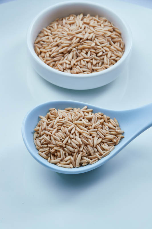 白色纸背景上的青釉瓷餐具及木质餐具装的燕麦米图片