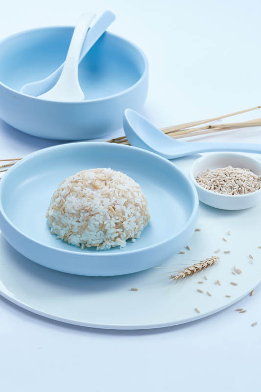 白色纸背景上的青釉瓷餐具及木质餐具装的燕麦米图片