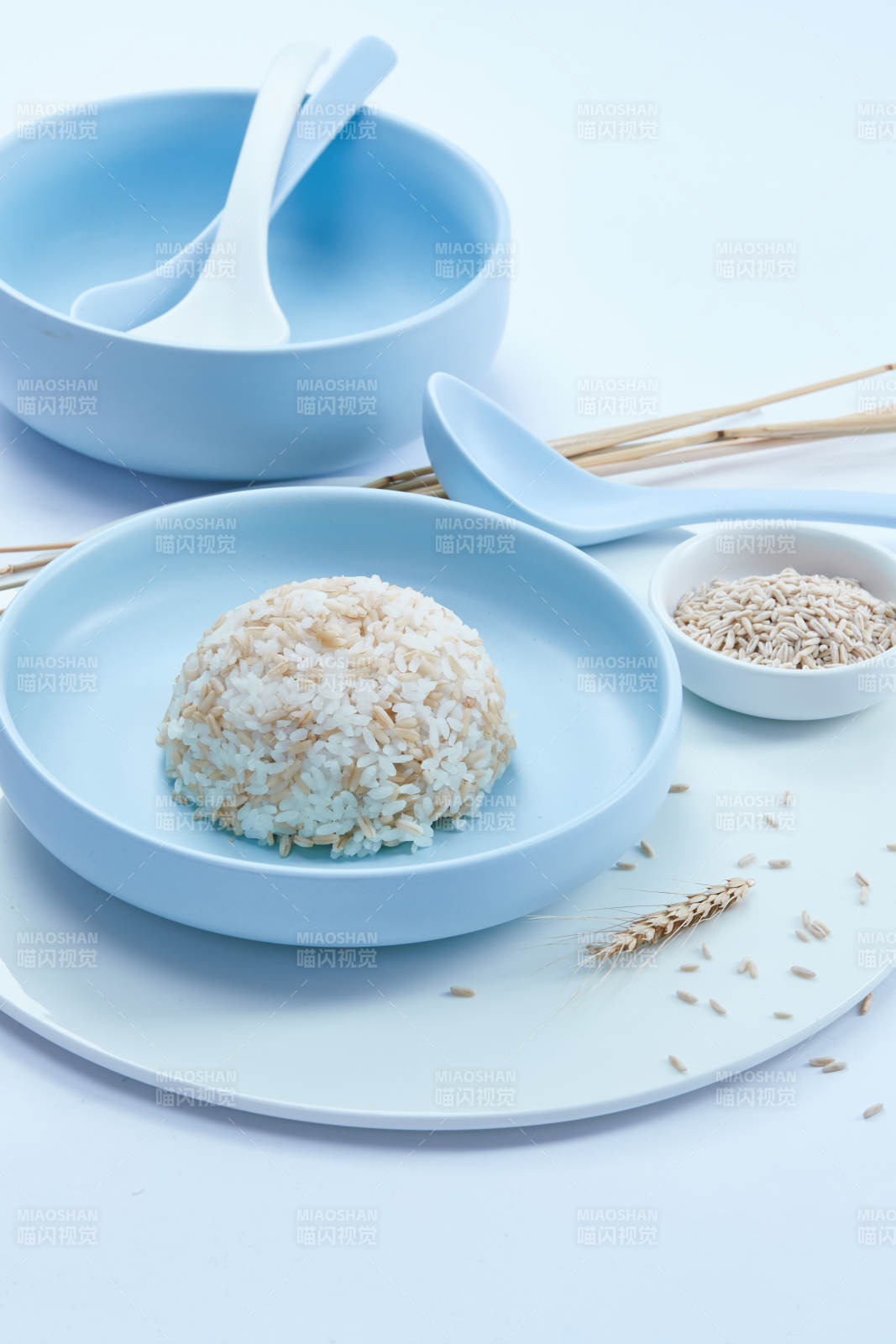 白色纸背景上的青釉瓷餐具及木质餐具装的燕麦米图片