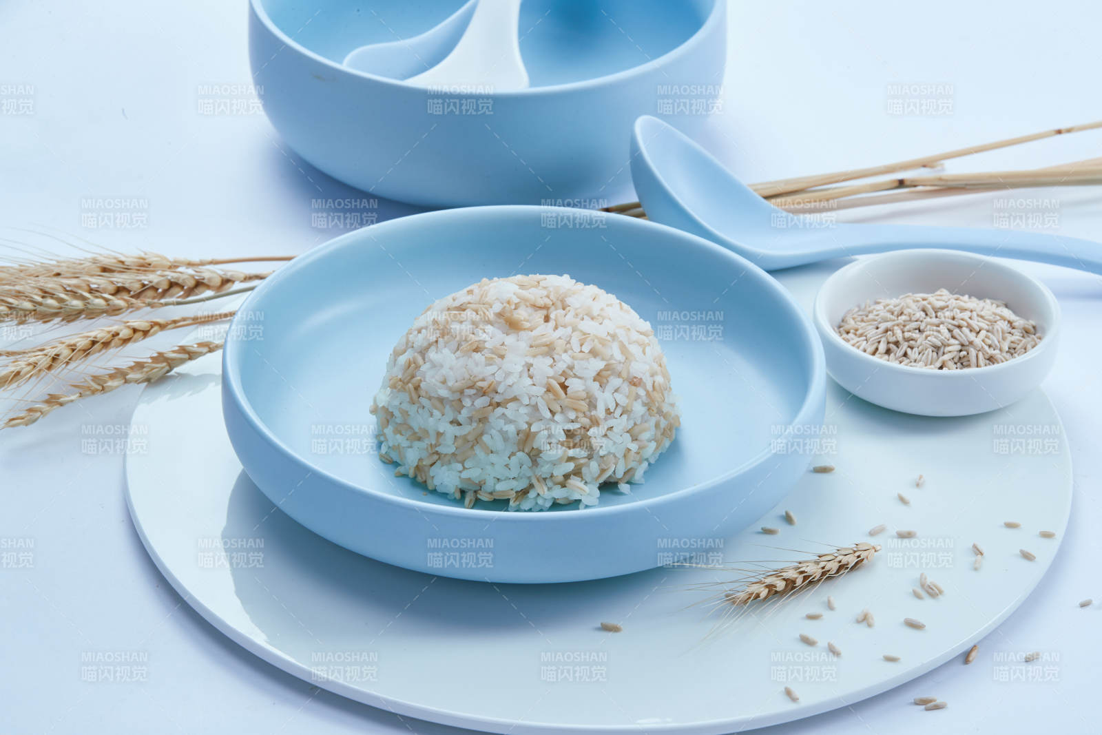 白色纸背景上的青釉瓷餐具及木质餐具装的燕麦米图片