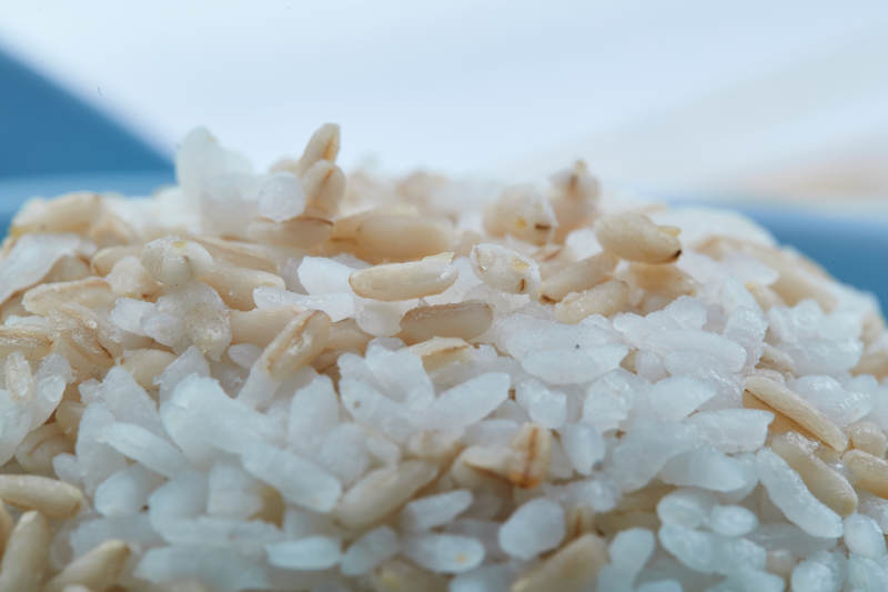 白色纸背景上的青釉瓷餐具及木质餐具装的燕麦米图片