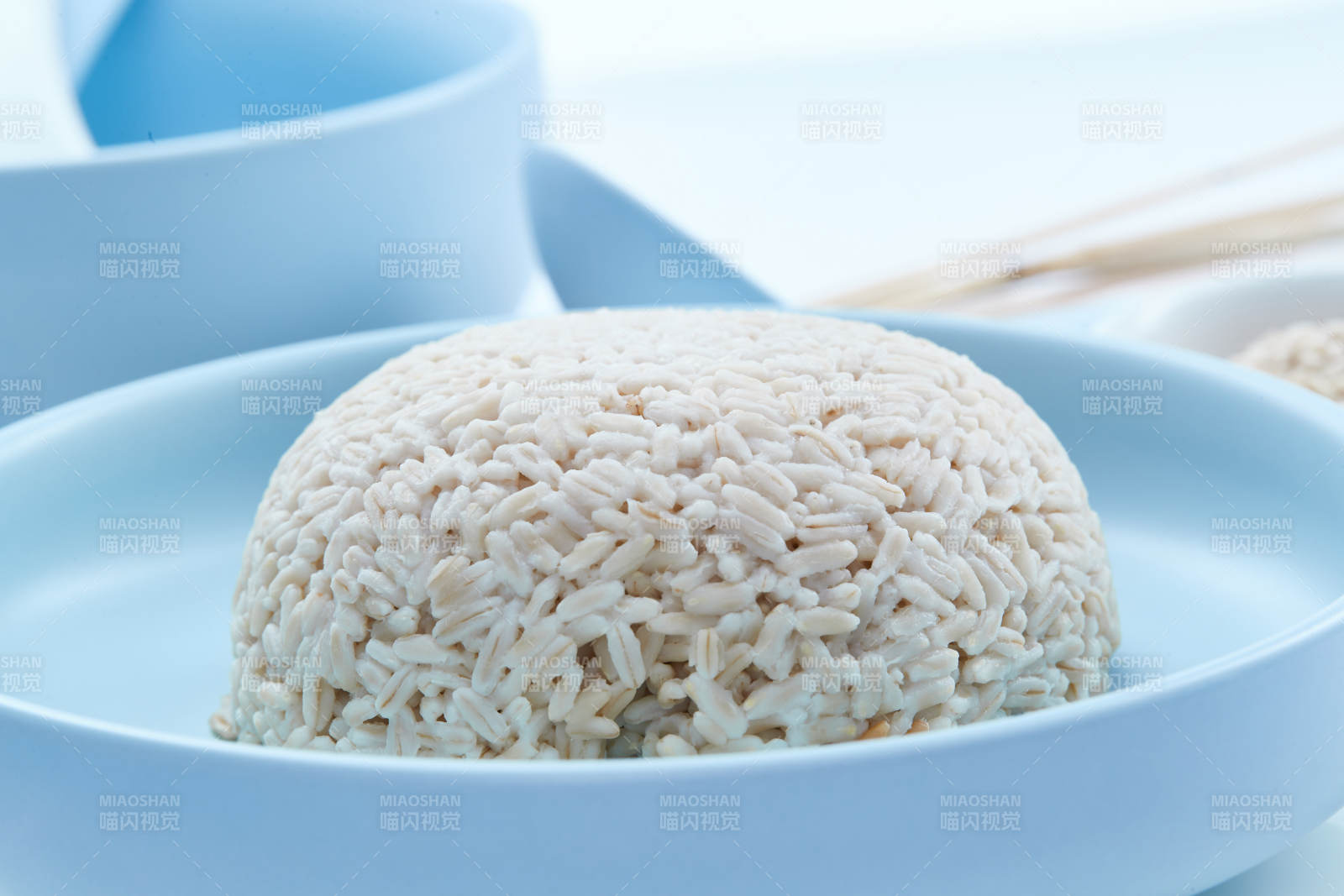 白色纸背景上的青釉瓷餐具及木质餐具装的燕麦米图片