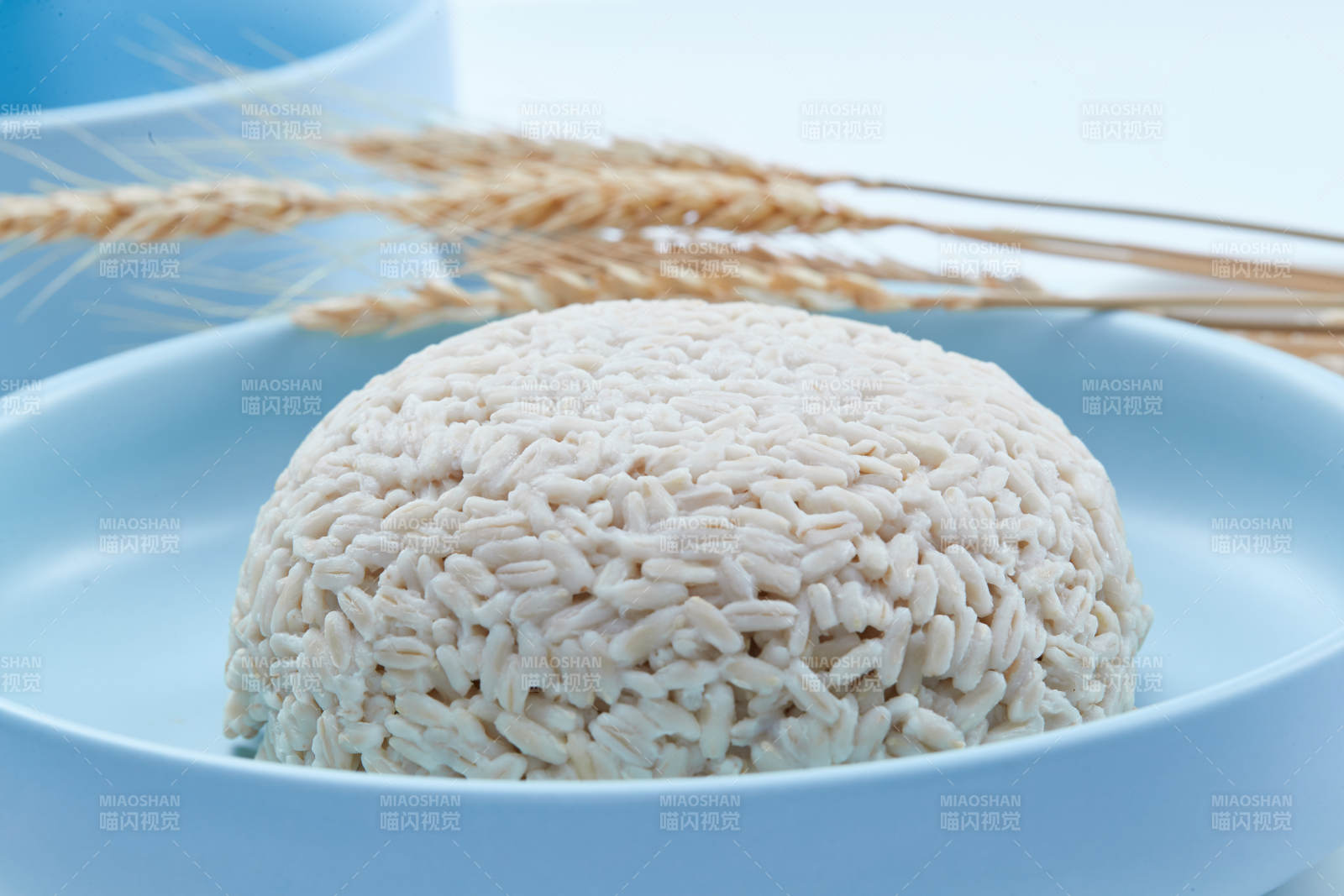 白色纸背景上的青釉瓷餐具及木质餐具装的燕麦米图片