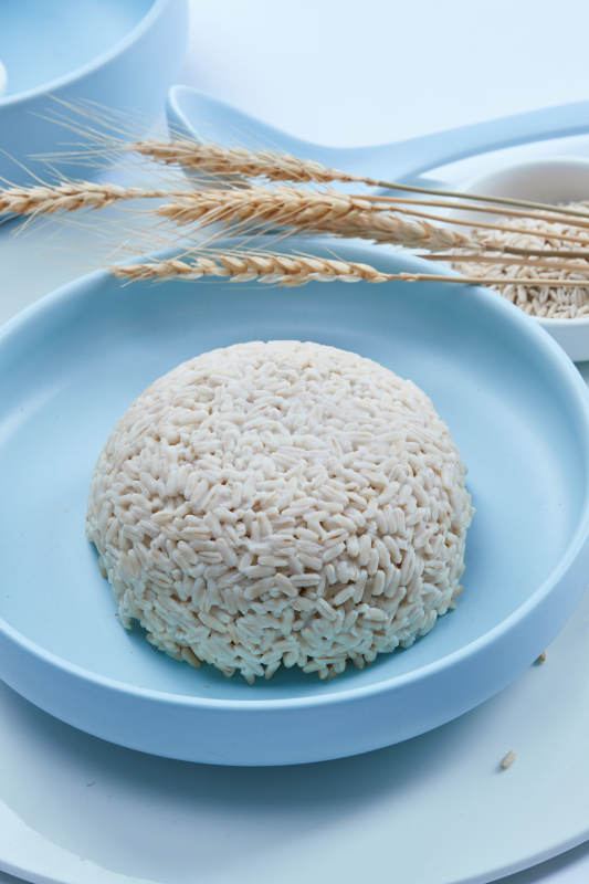 白色纸背景上的青釉瓷餐具及木质餐具装的燕麦米图片