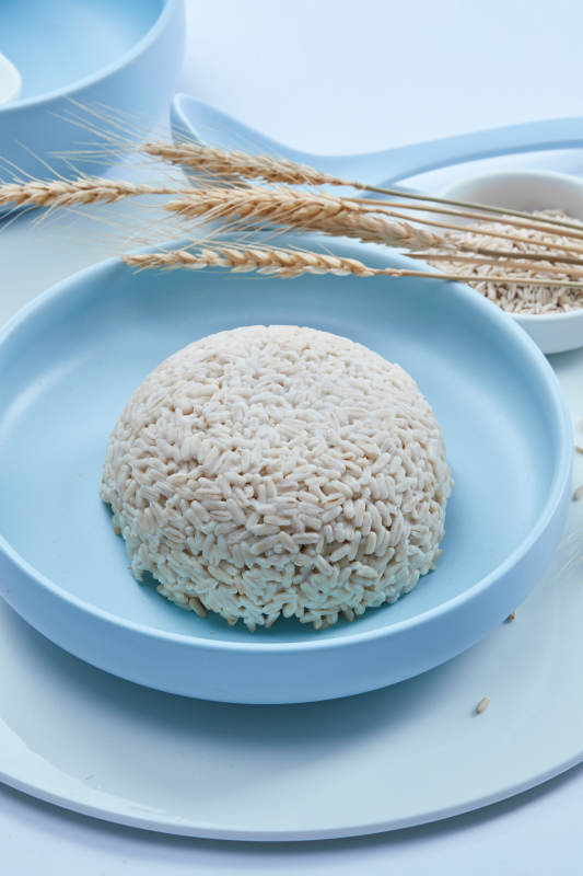 白色纸背景上的青釉瓷餐具及木质餐具装的燕麦米图片