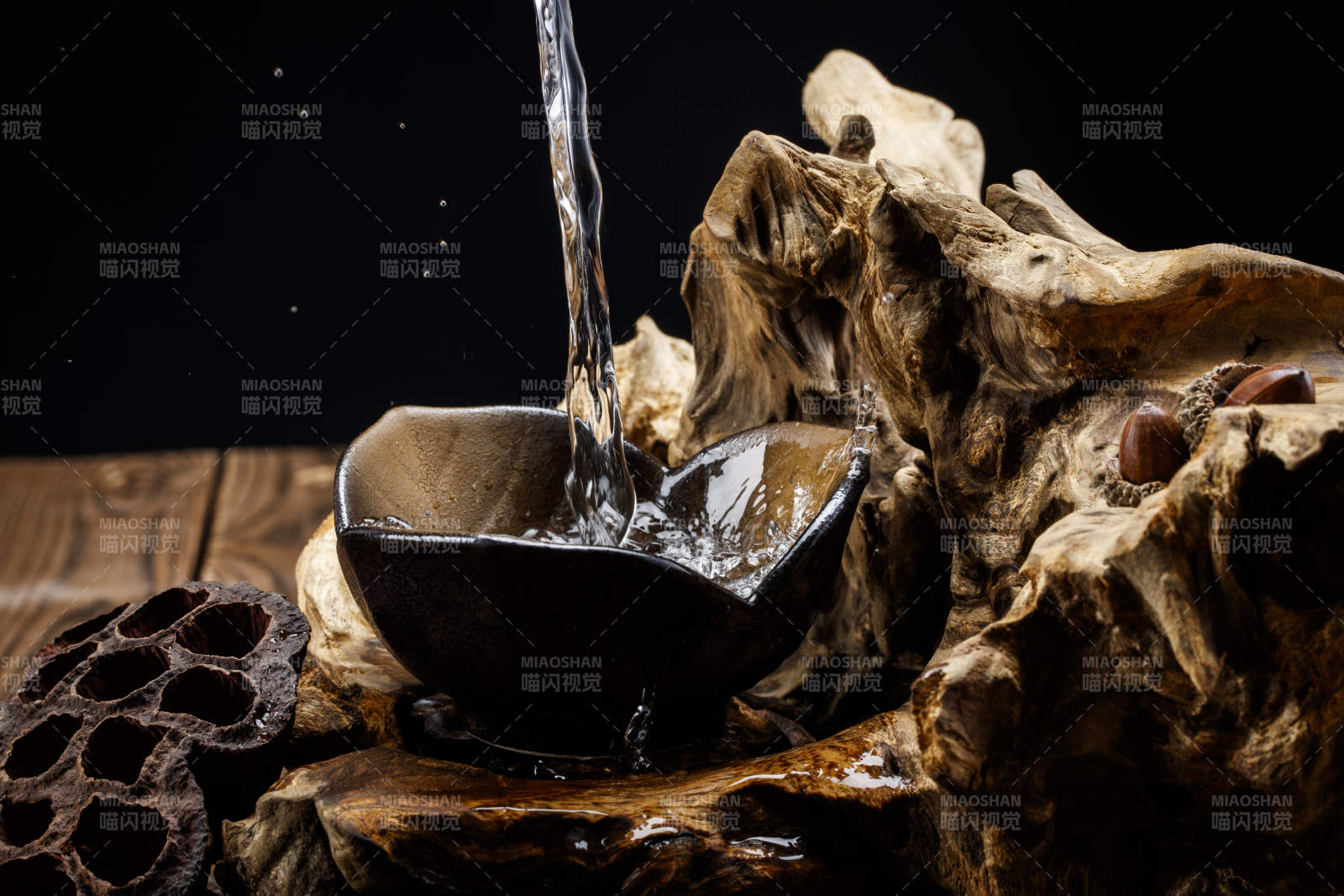 向木板上摆放的酒具内倒入清澈的白酒激起无数酒花图片