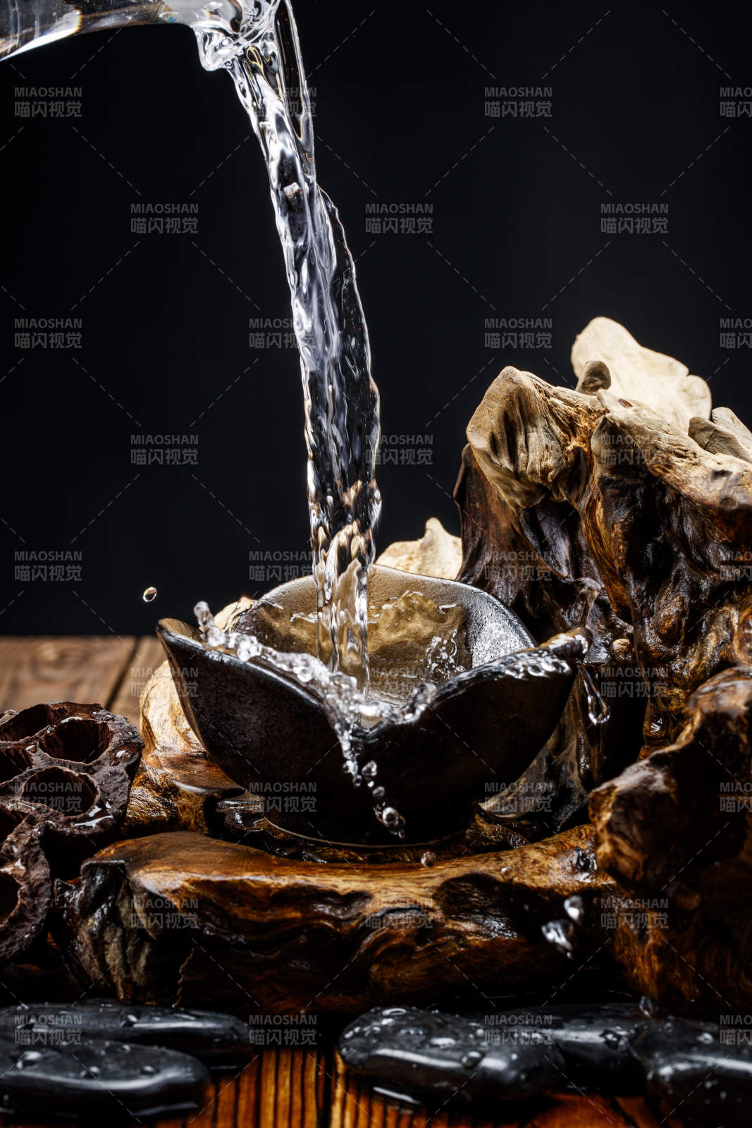 向木板上摆放的酒具内倒入清澈的白酒激起无数酒花图片