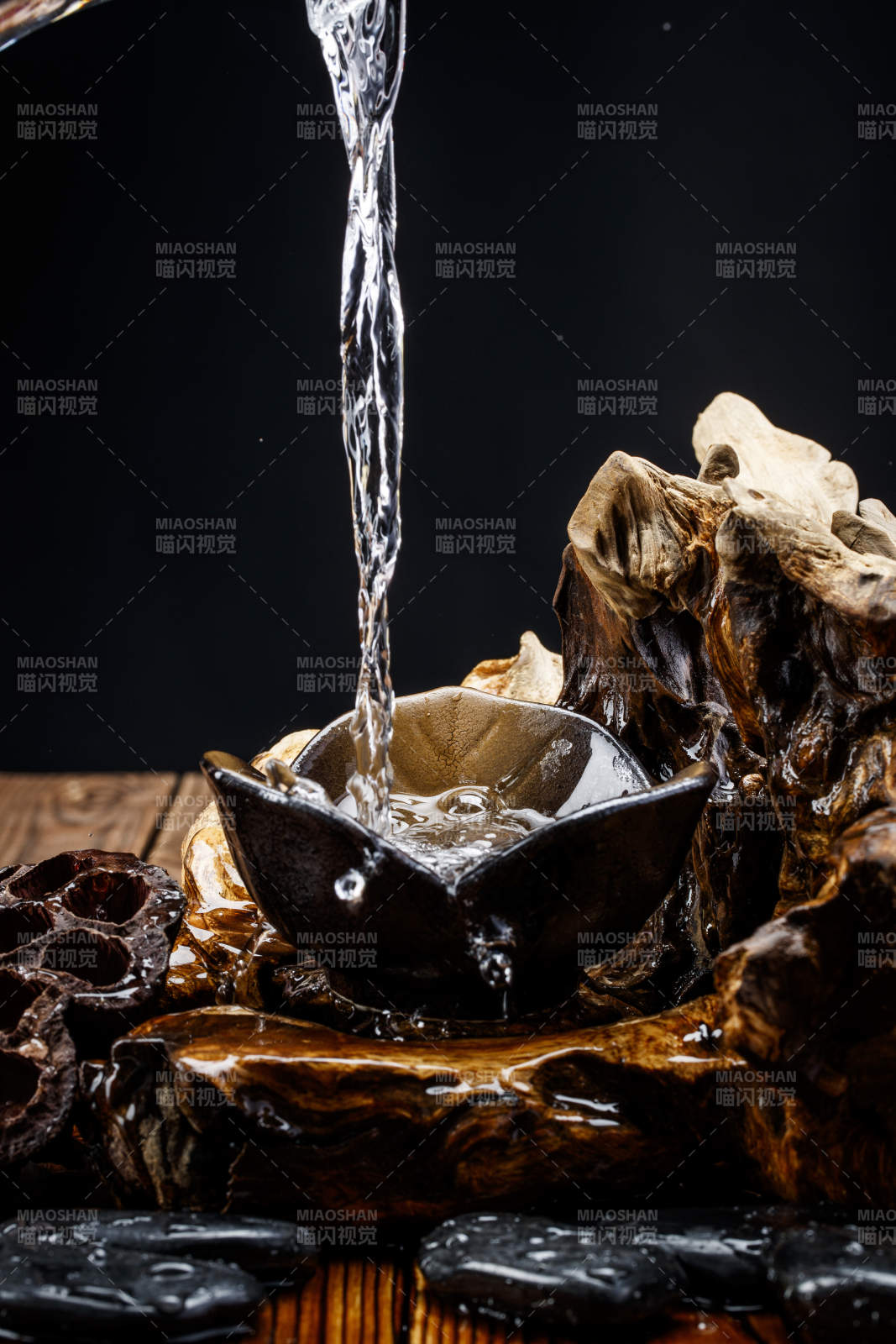 向木板上摆放的酒具内倒入清澈的白酒激起无数酒花图片