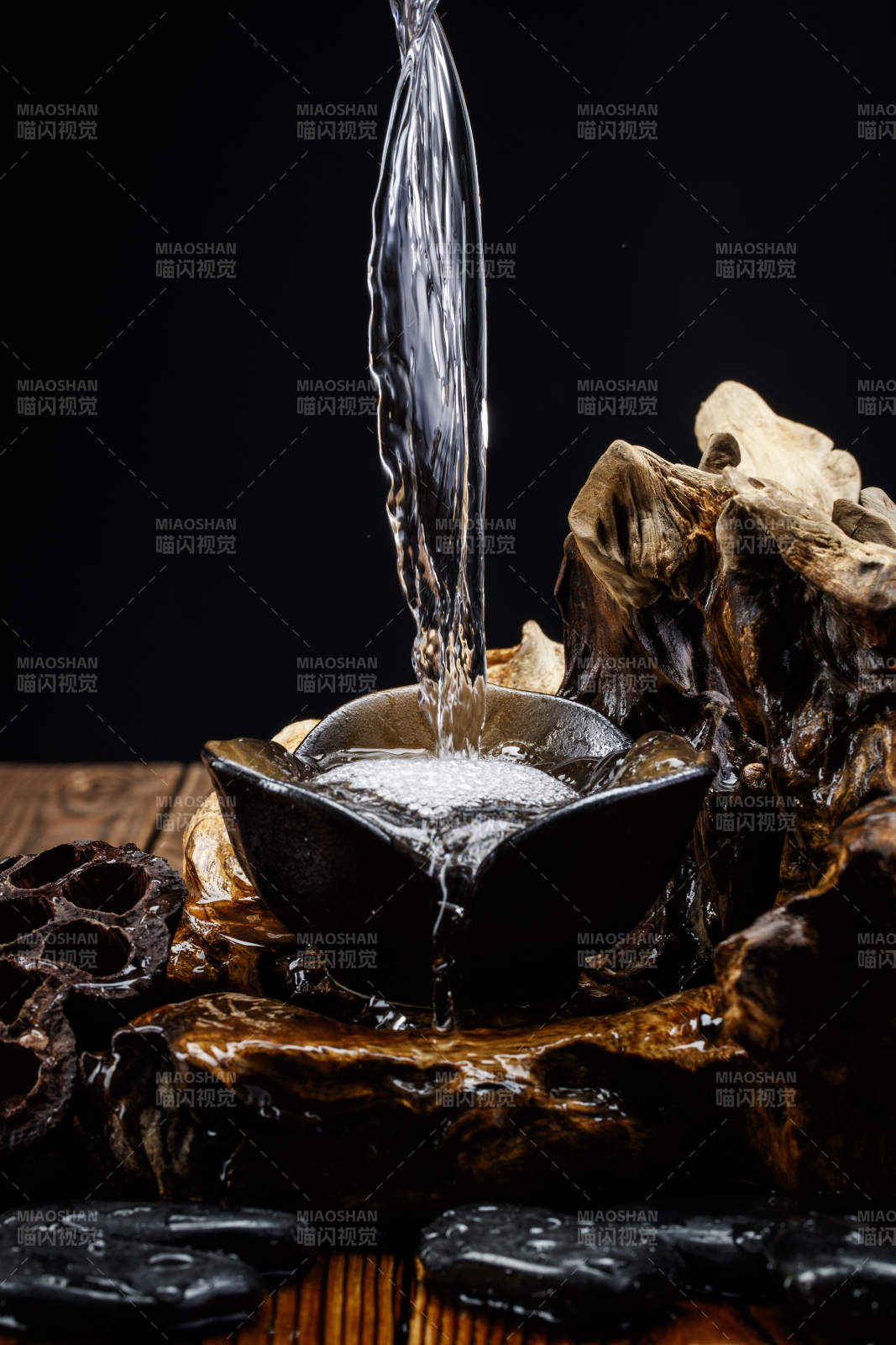 向木板上摆放的酒具内倒入清澈的白酒激起无数酒花图片